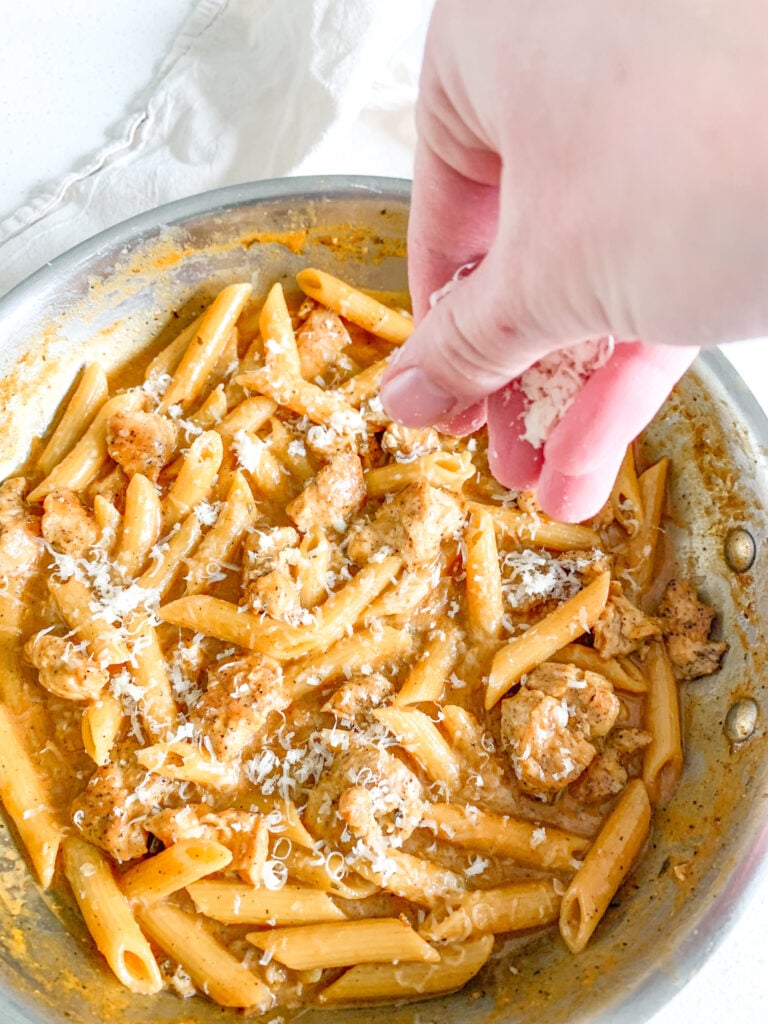 adding parmesan on top of cajun chicken alfredo before serving