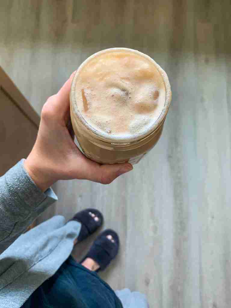 woman holding foamy cold coffee
