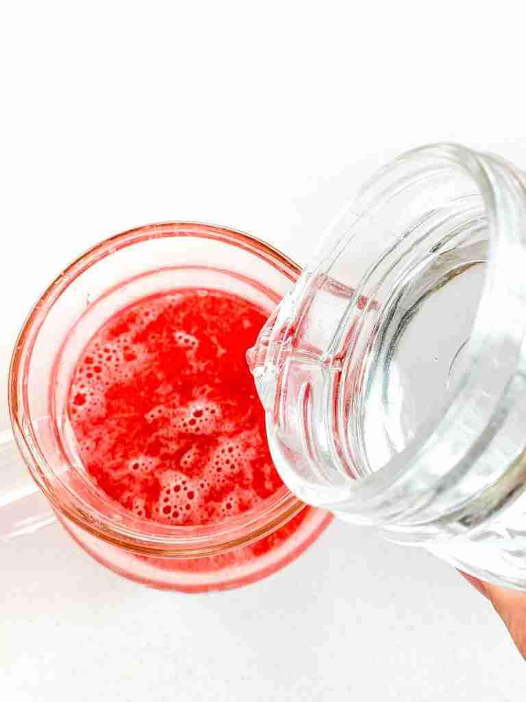 pouring water into pitcher full of watermelon juice