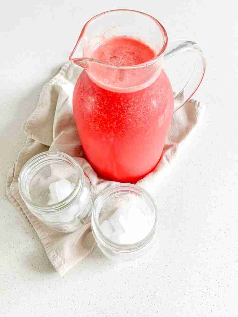 freshly made watermelon lemonade in a pitcher with 2 glasses of ice