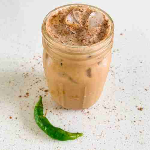 mason jar of coffee with a pepper next to it