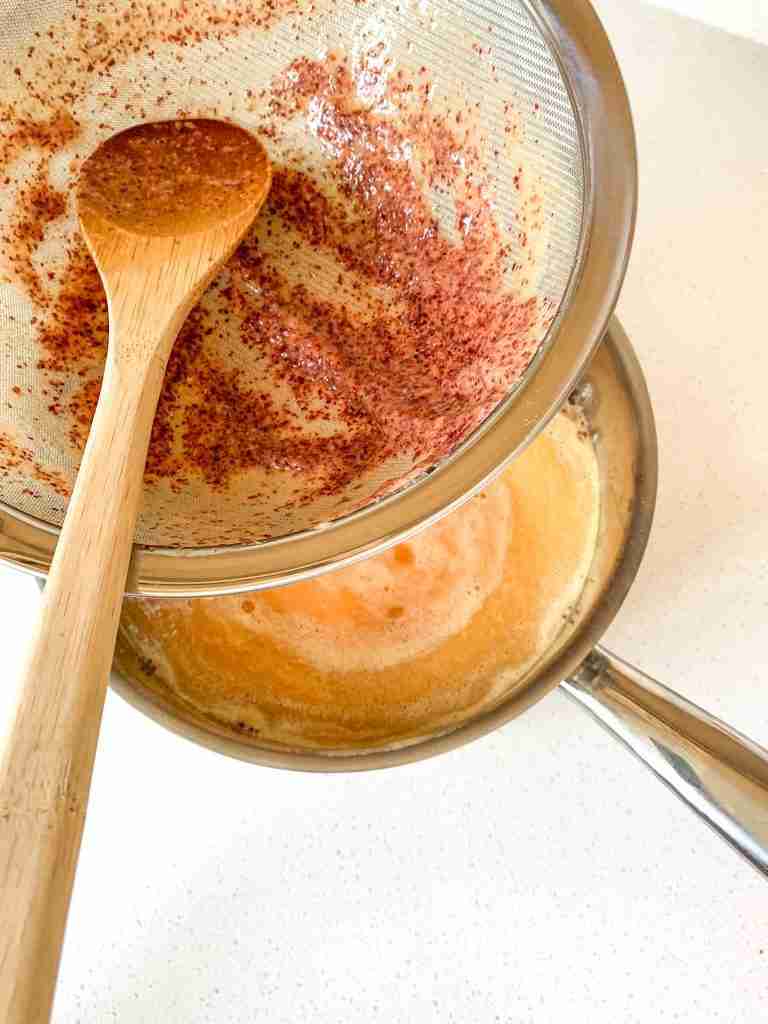 straining peach juice into tea