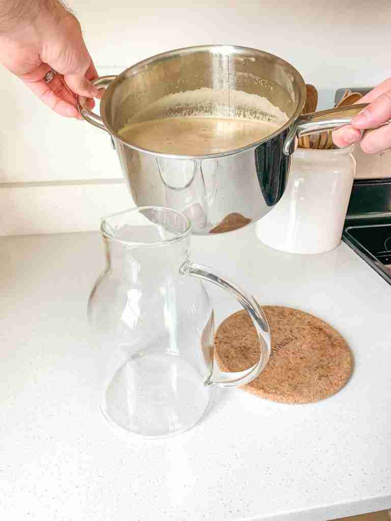 pouring peach tea into a pitcher