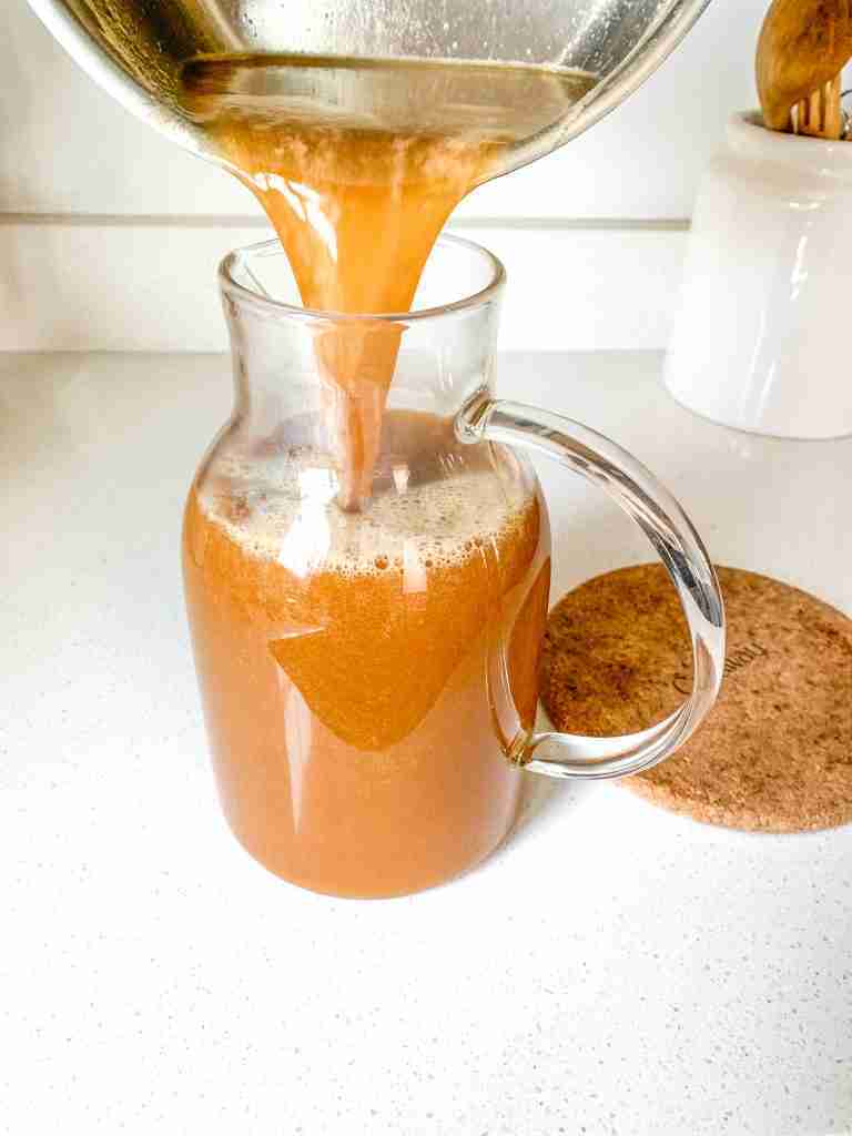 pouring tea into a pitcher