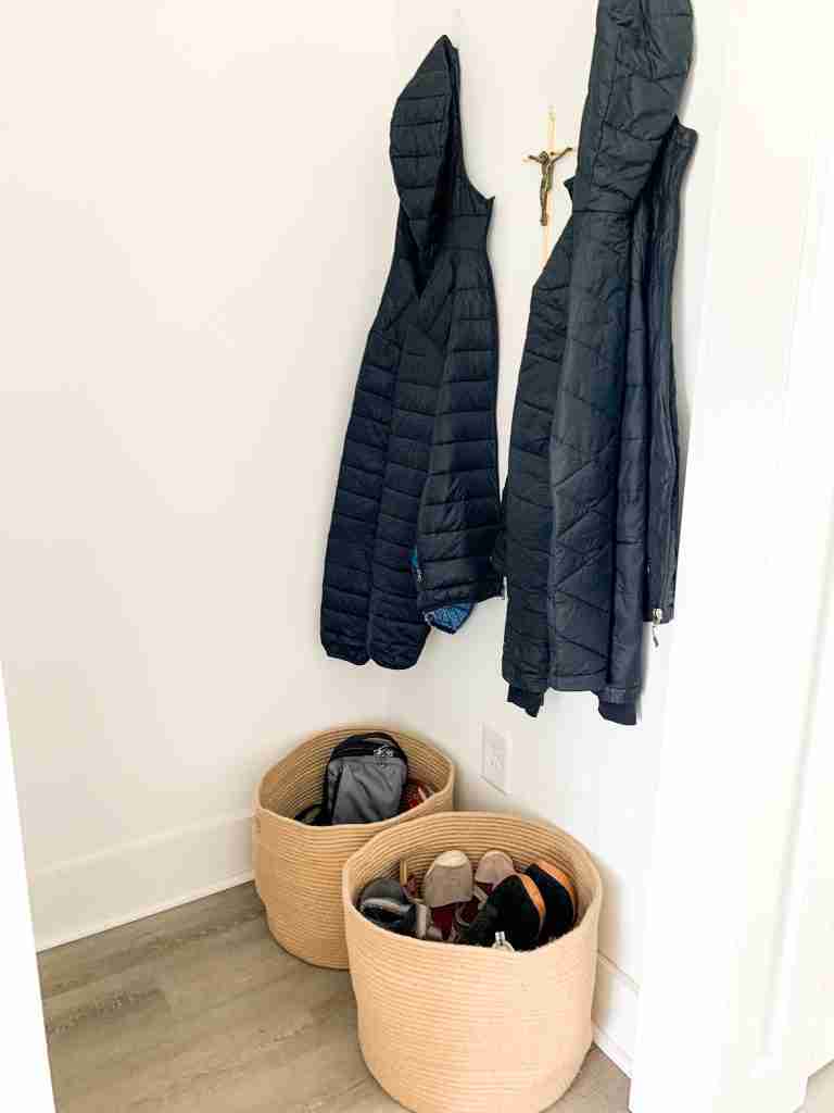 entryway with baskets and coats hanging up