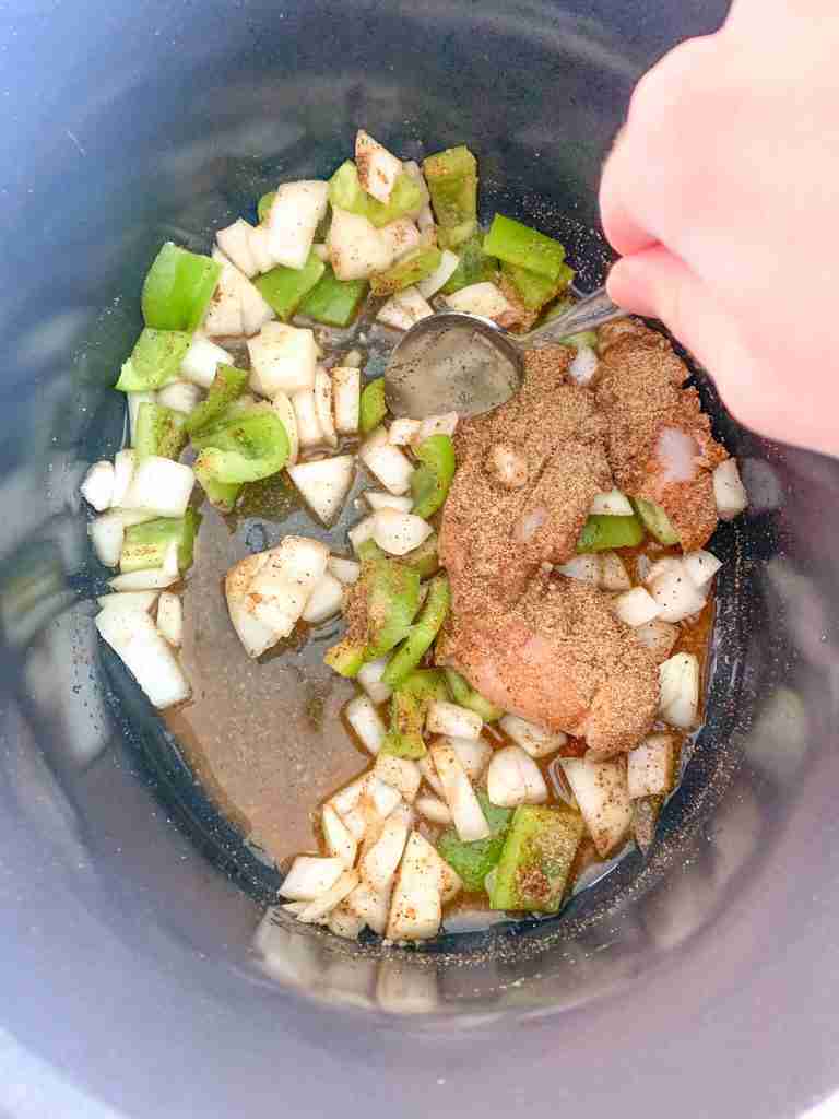 ingredients being stirred in fajita slow cooker
