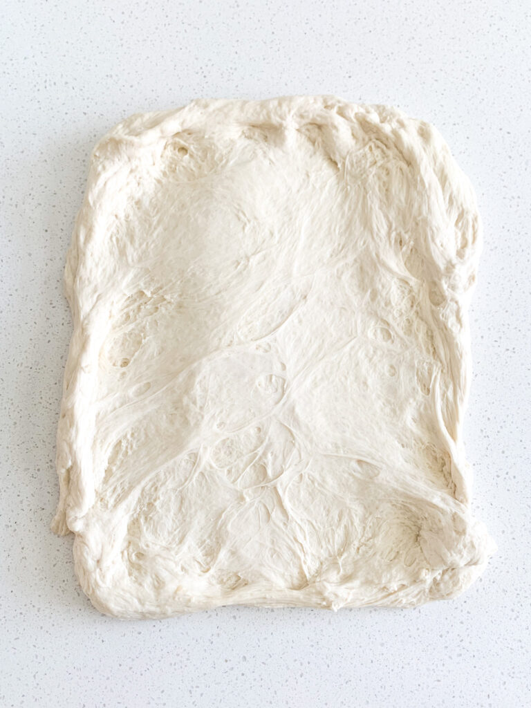 sourdough bread dough stretched out for shaping