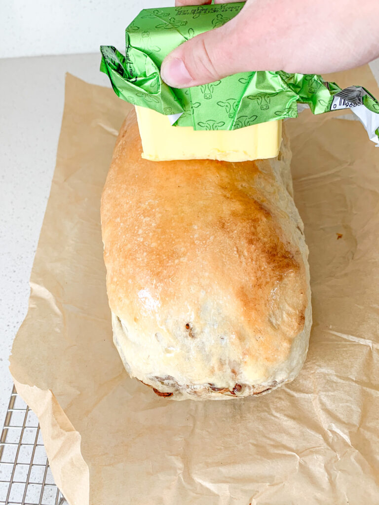 rubbing butter on freshly baked bread