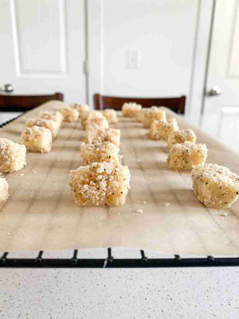 unbaked mozzarella on a wire rack breaded
