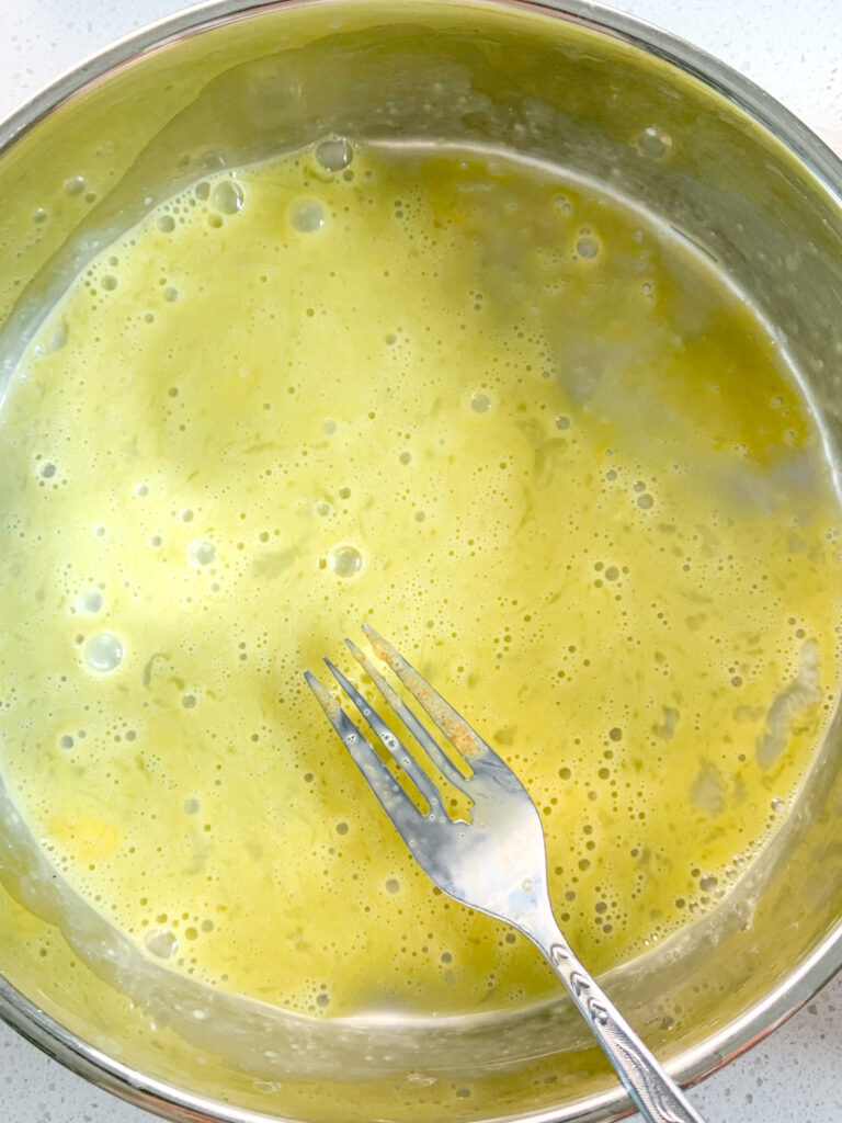 whisking egg with a fork for breading