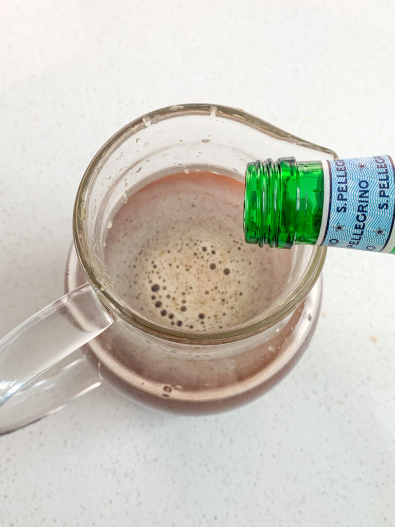 adding sparkling water into Christmas punch base