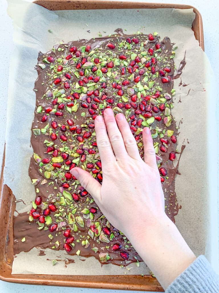 pushing toppings down into melted chocolate