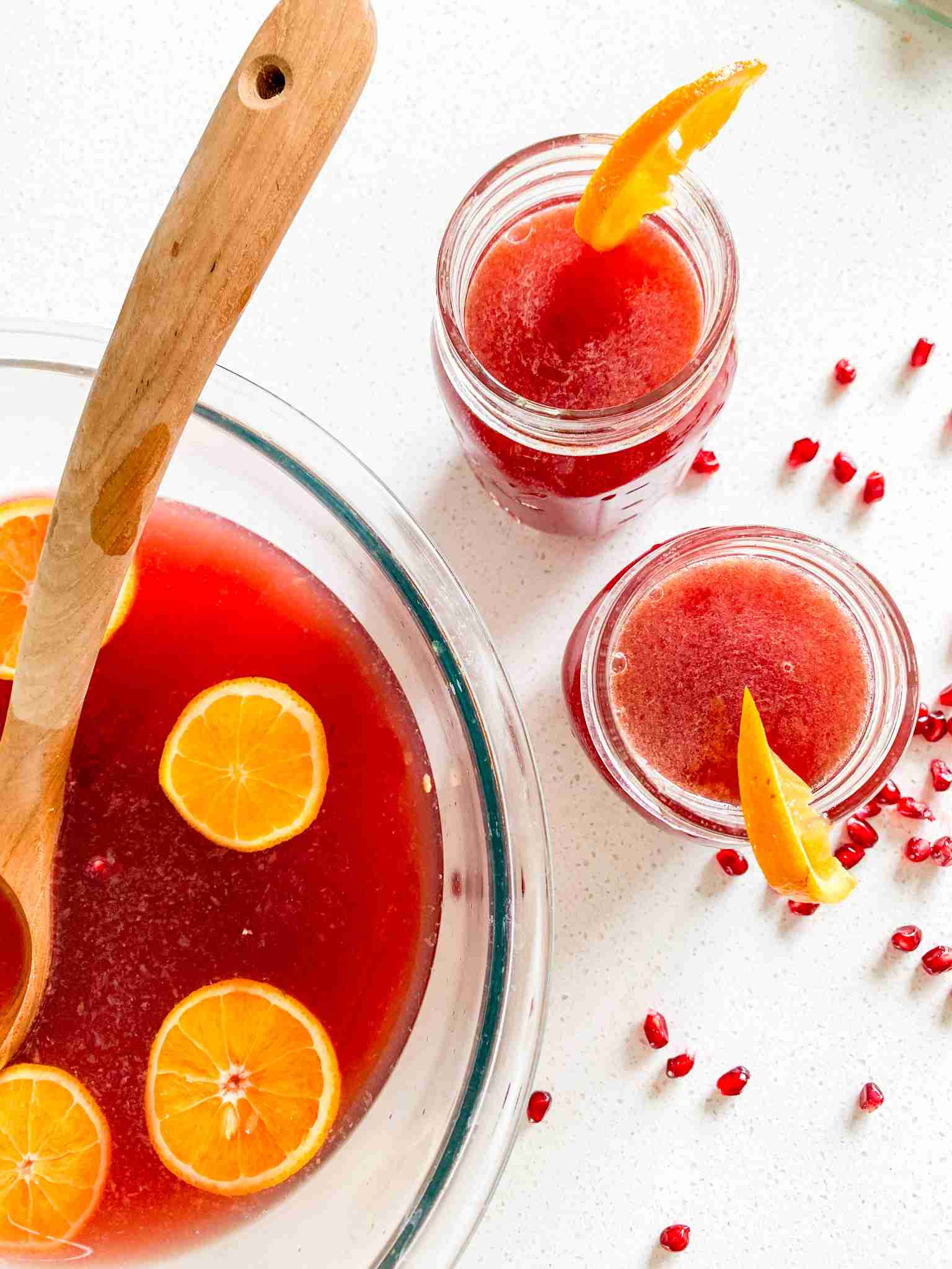 large punch bowl full of ingredients and 2 glasses ready to drink from