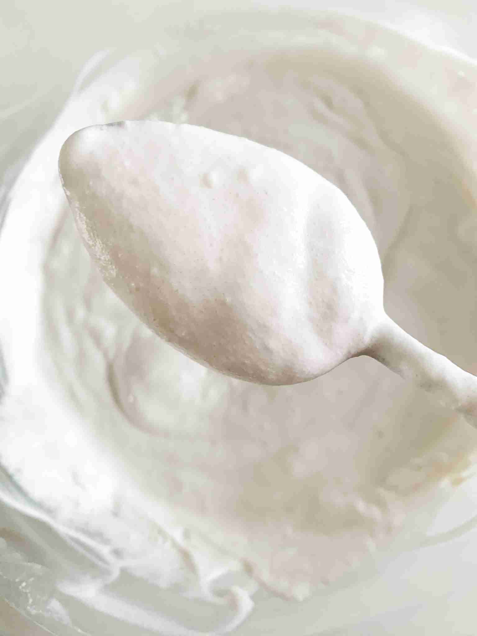 spoon full of whipped cream coming out of the bowl