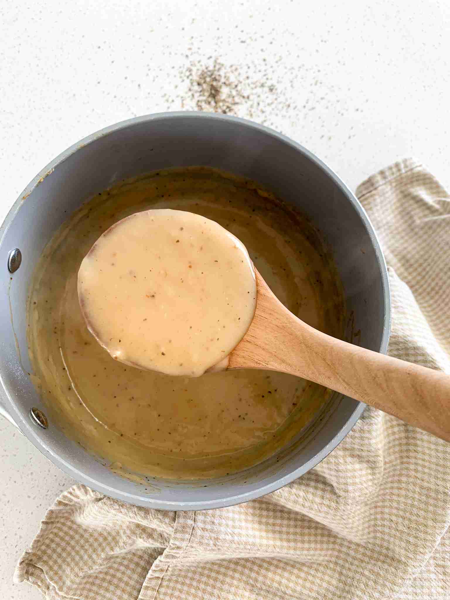 bamboo ladle getting homemade brown gravy out of pot