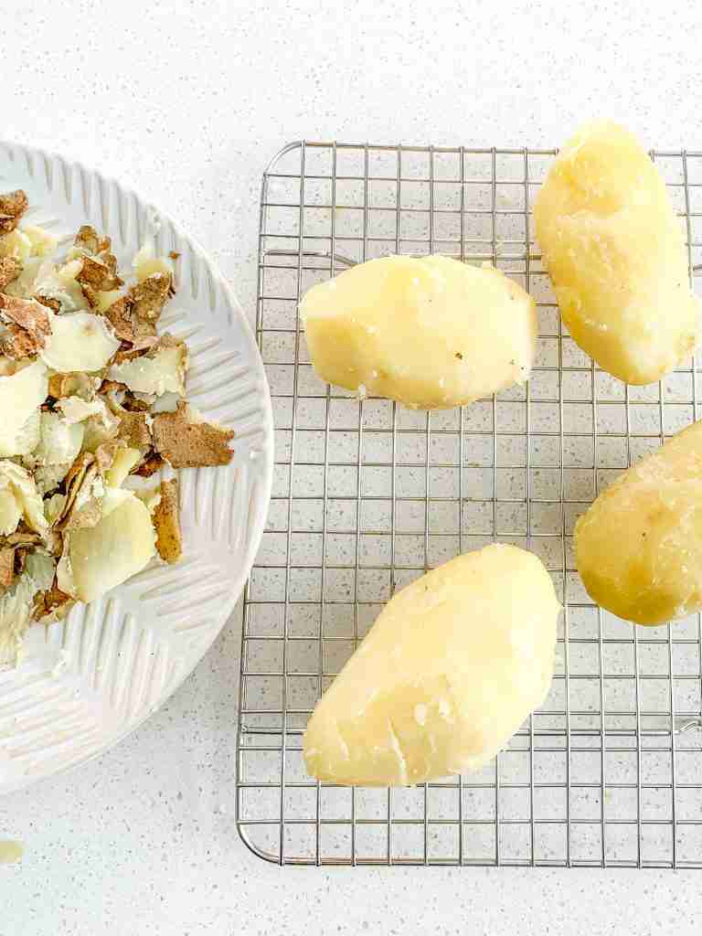 cooked potatoes peeled and ready to be grated into bowl