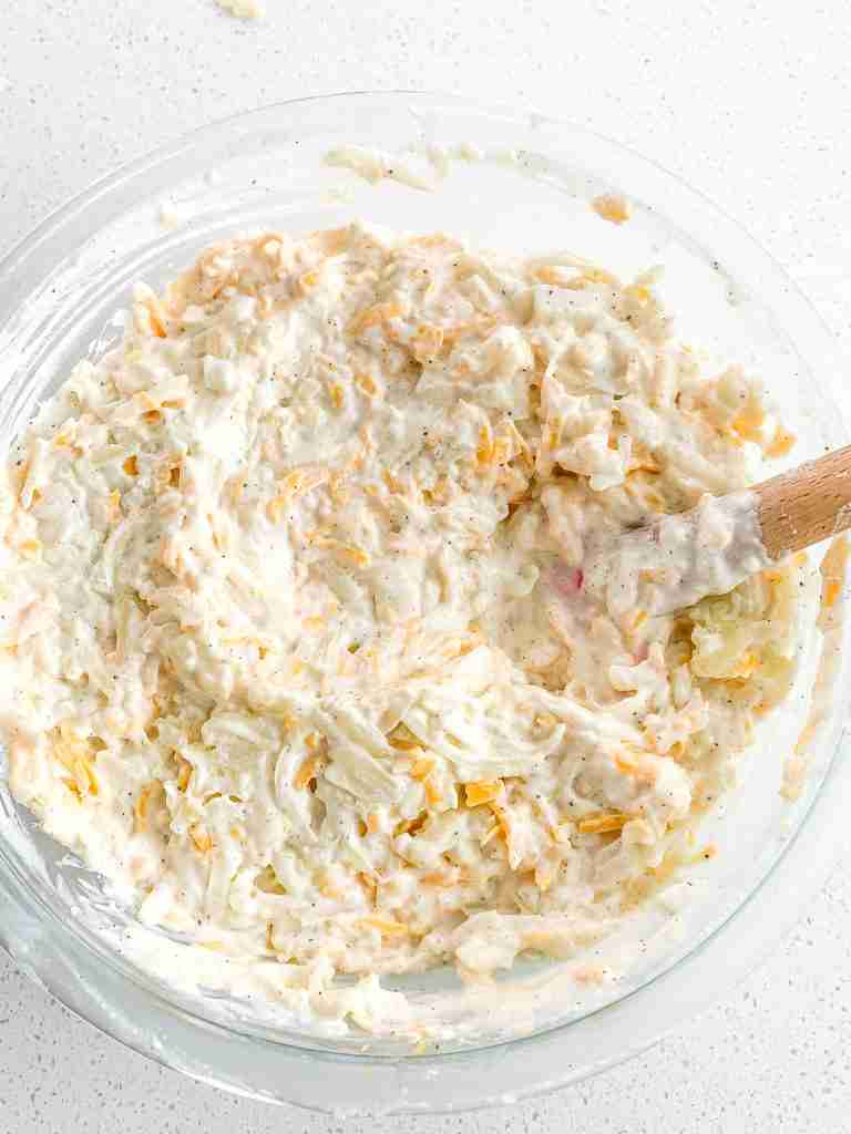 stirring together hashbrown casserole ingredients