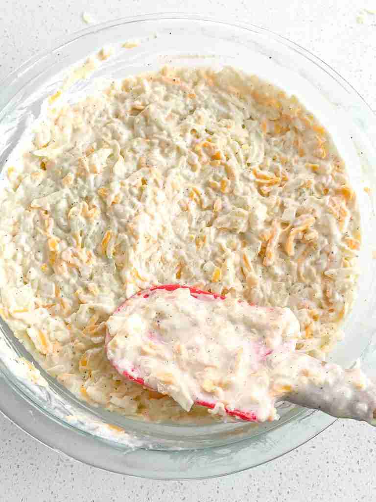 smoothing out hashbrown casserole mixture in dish