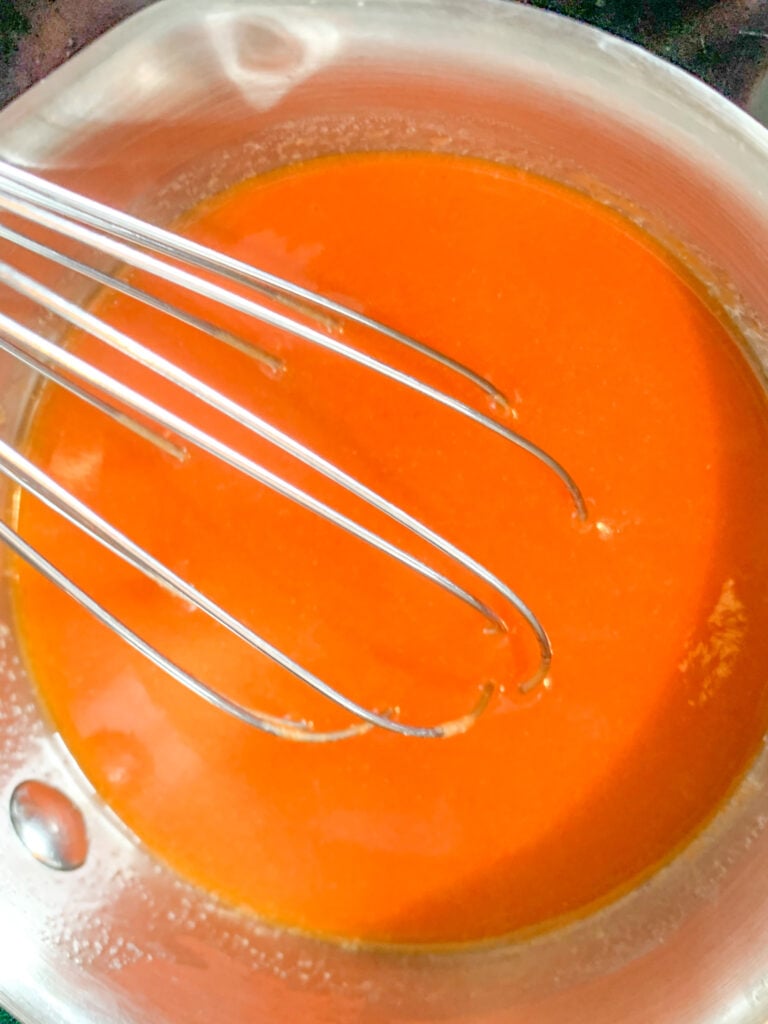 whisking homemade buffalo sauce