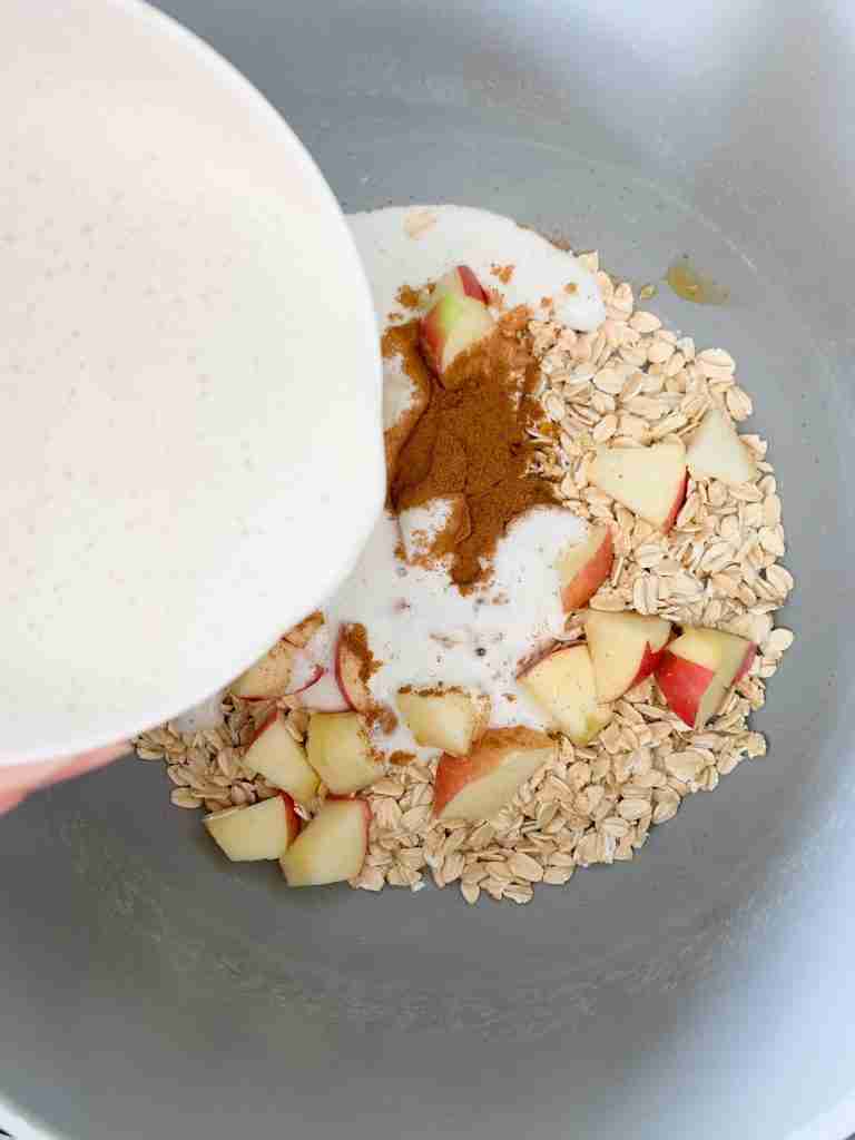 hand pouring milk into a pot with other ingredients