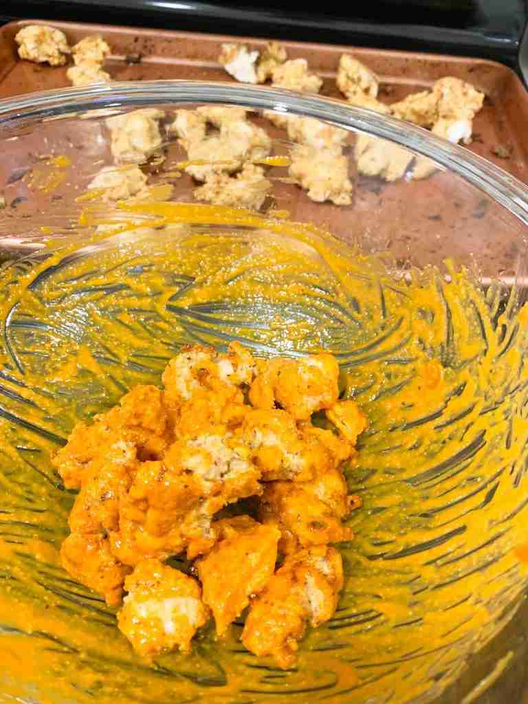 wings being tossed in sauce