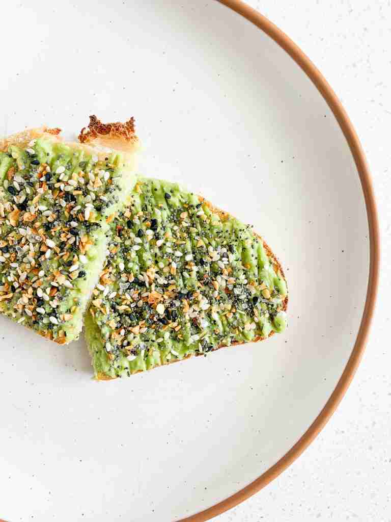 2 slices of toast with avocado spread on top with seasoning