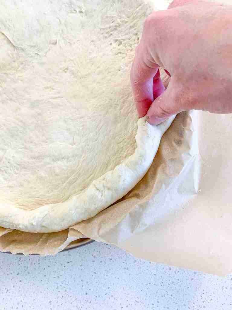 rolling the crust of the pizza dough