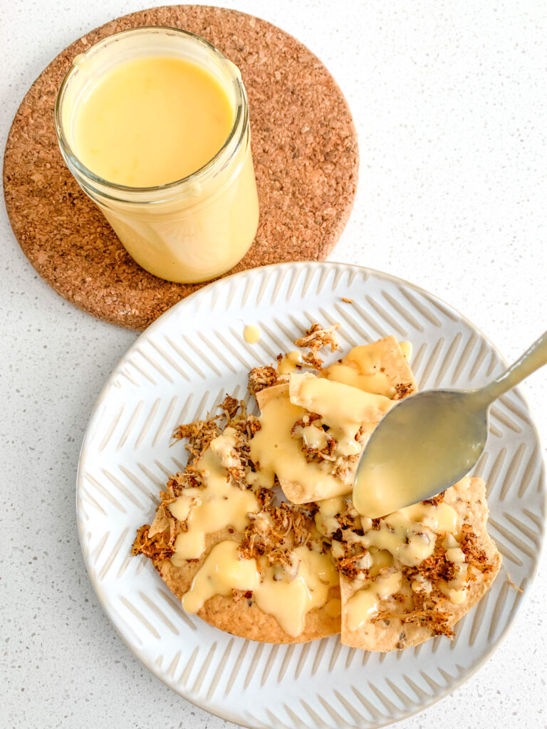 drizzling cheese dip over nachos