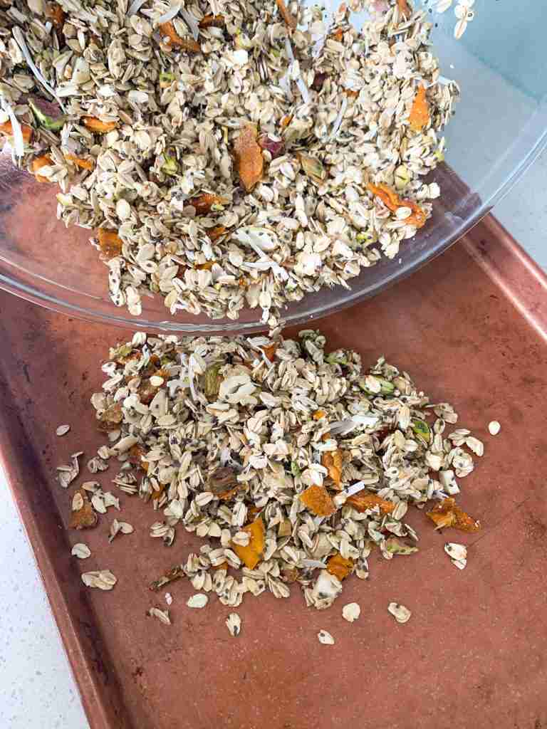 pouring granola on a sheet pan