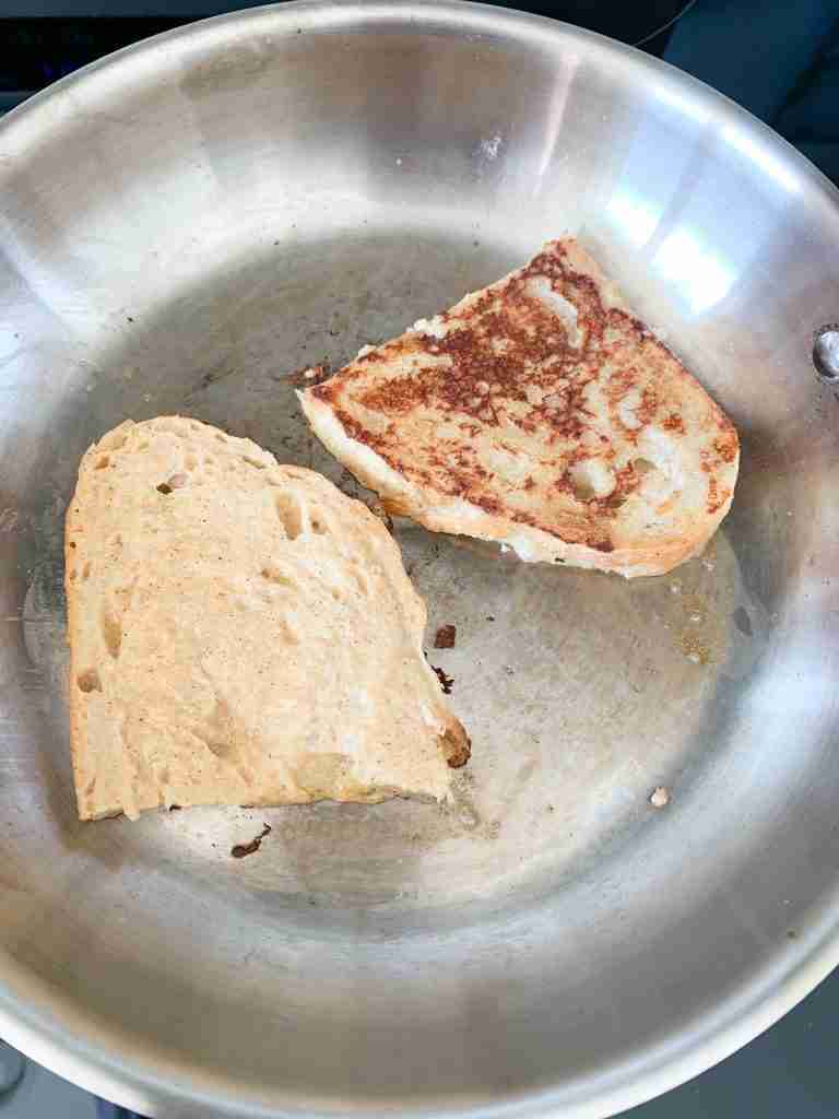 2 slices of toast cooking in a pan