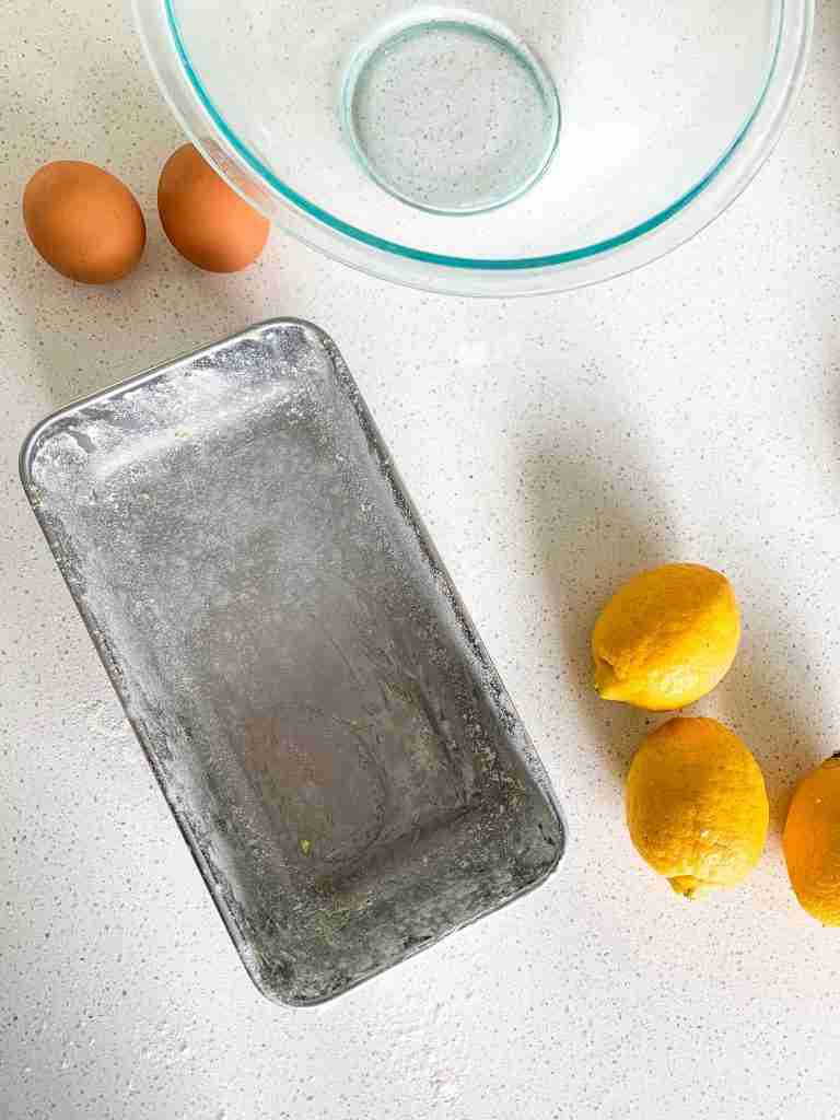preparing a loaf pan with flour