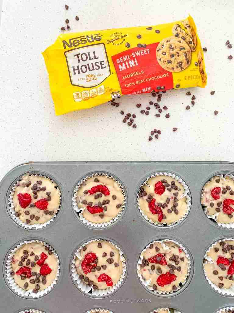 garnishing muffin batter with chocolate and berries