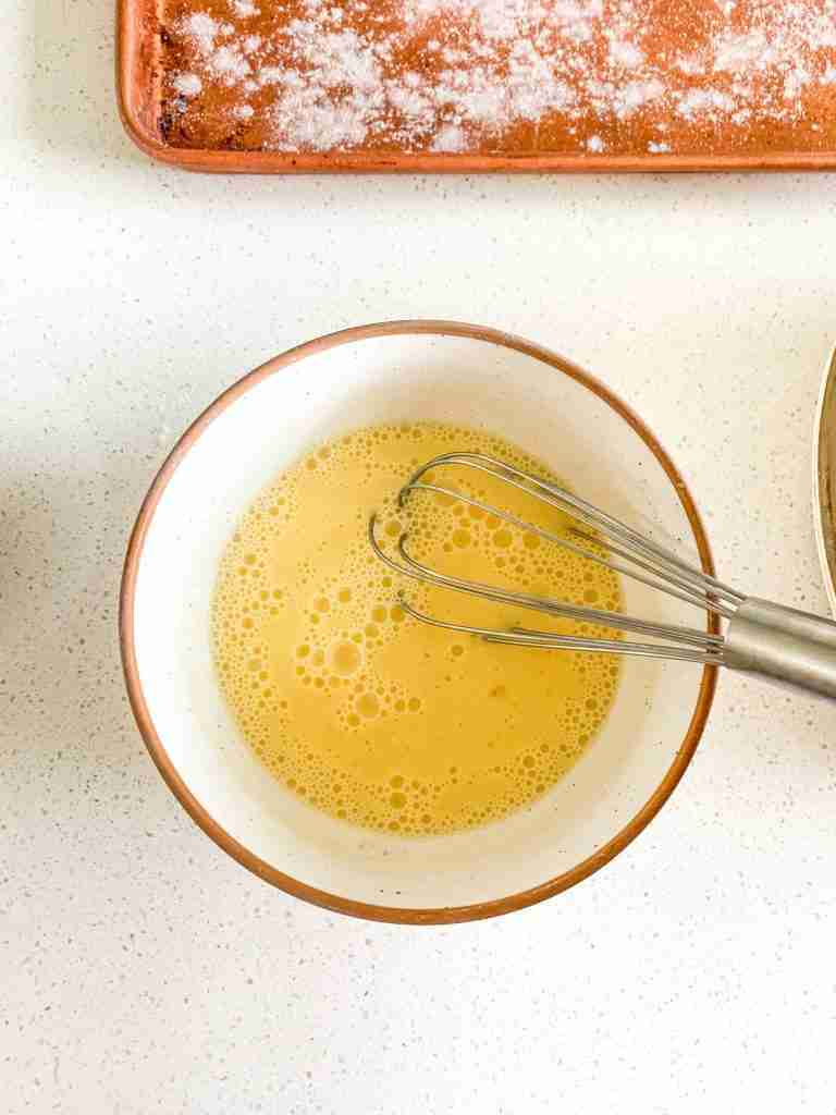 whisking eggs and milk in a bowl