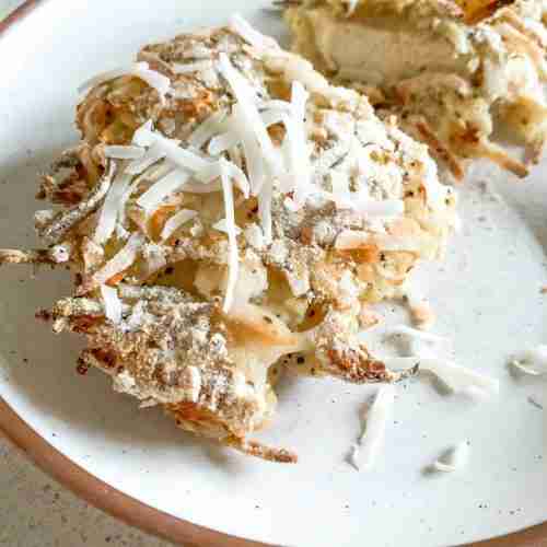 piece of chicken with coconut on top on a plate