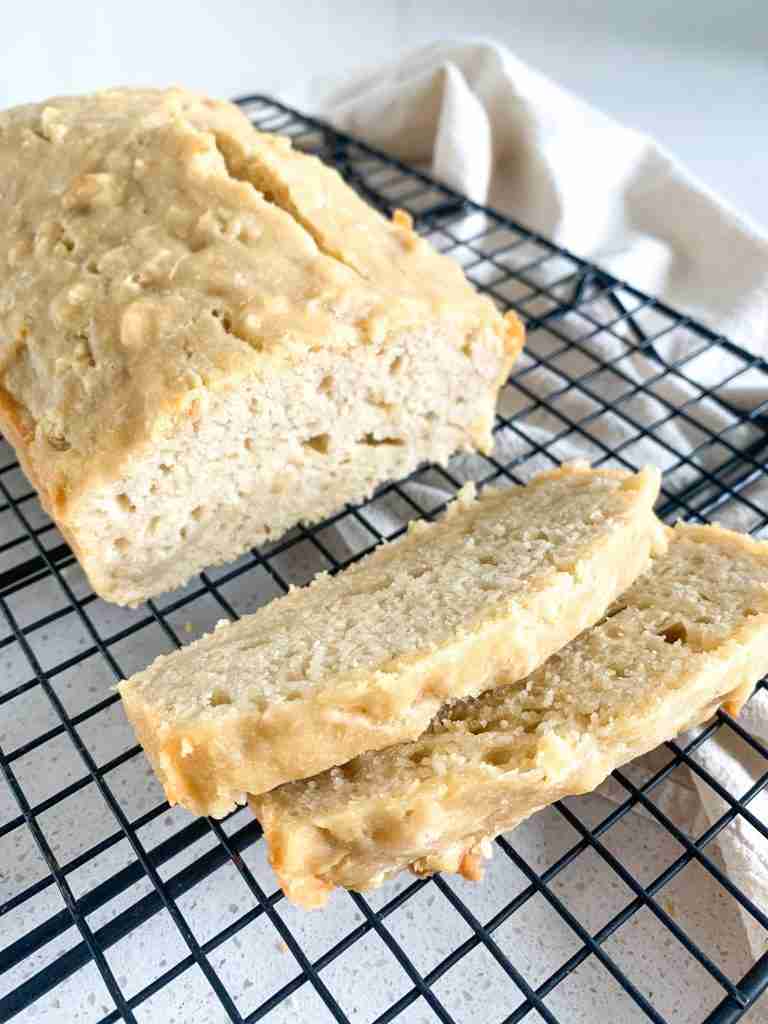 loaf of bread with 2 slices cut off all on a wire rack cooling
