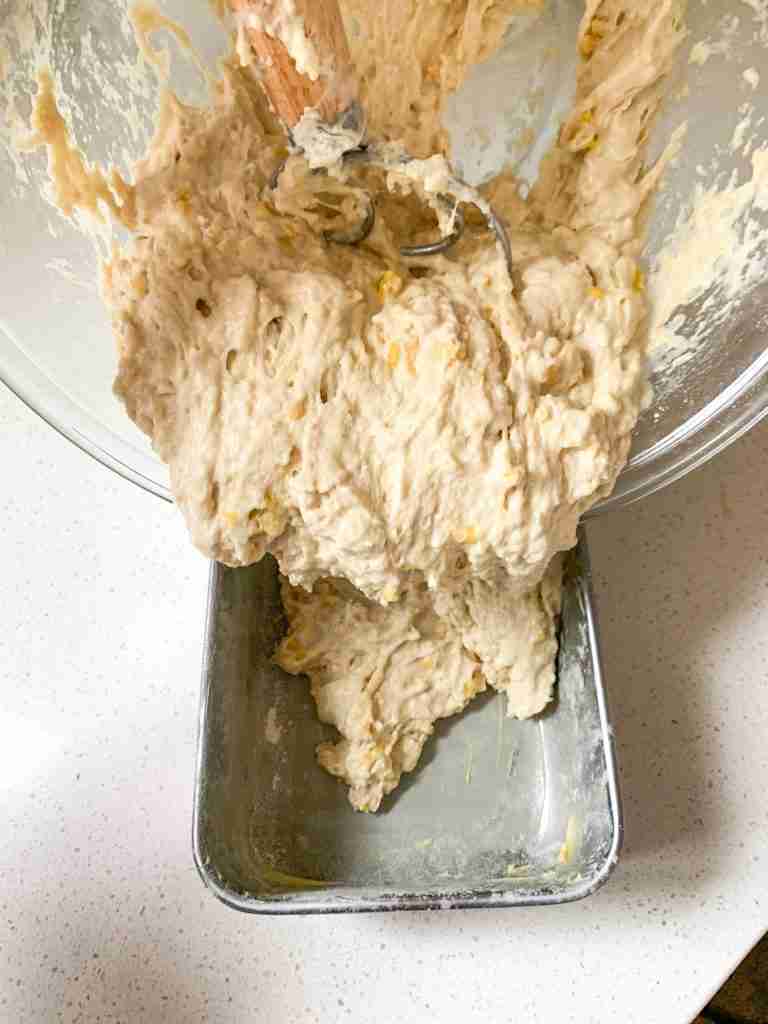 pouring batter into a loaf pan 