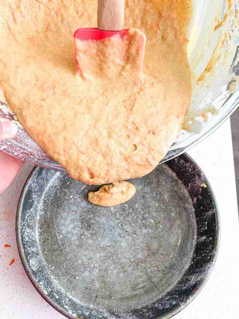pouring batter into a cake pan 