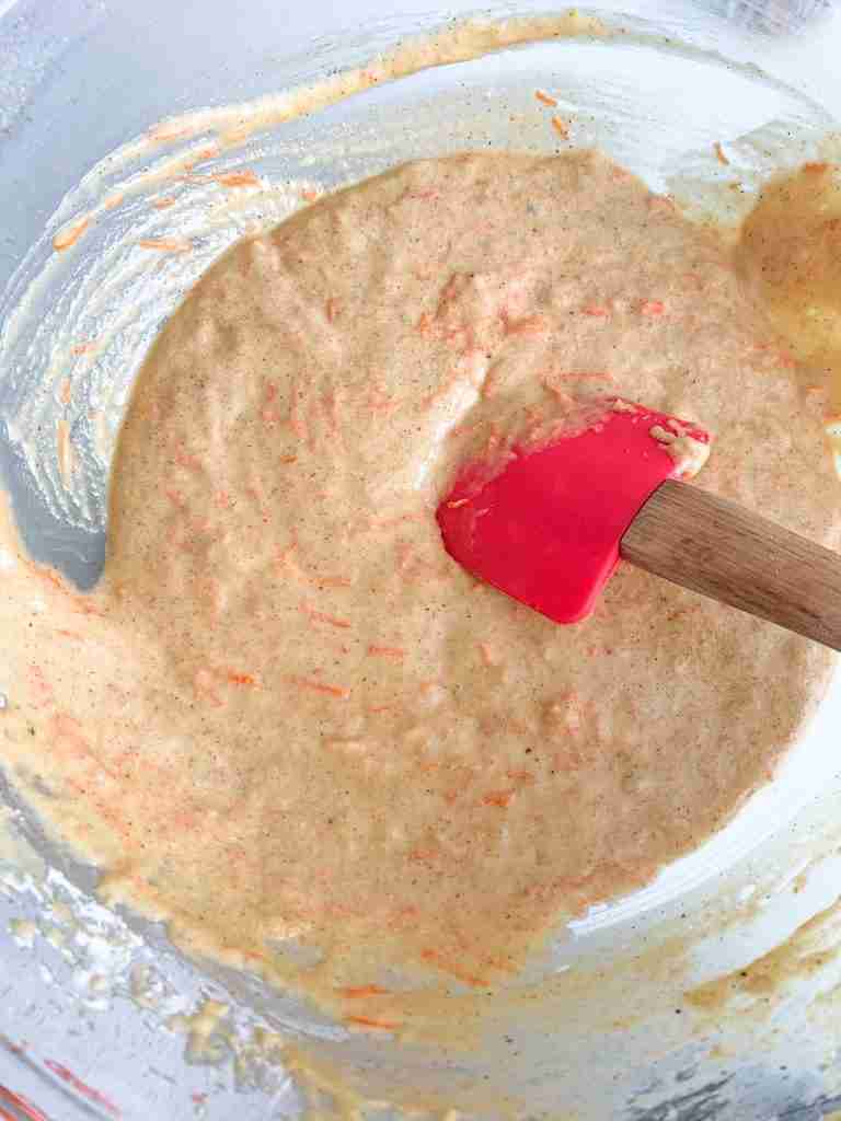 carrots being stirred into a batter