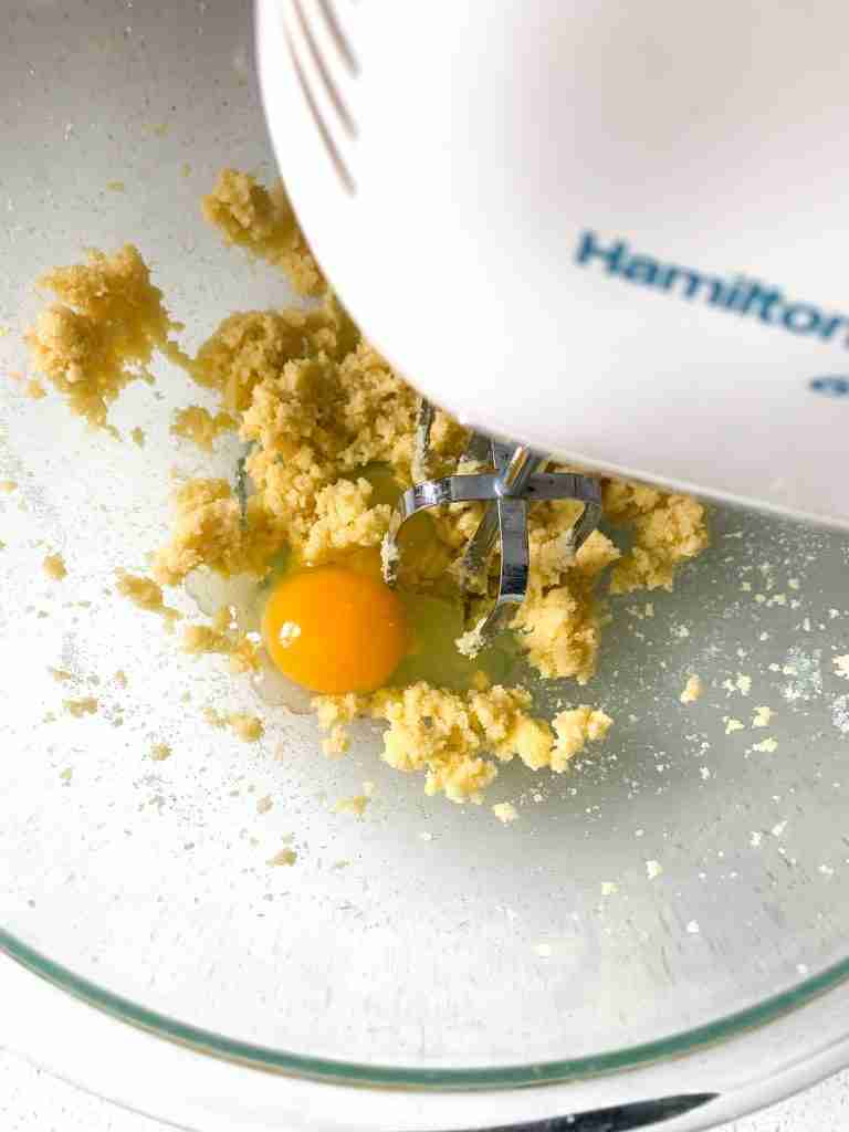 creamed sugar and butter with an egg being mixed in a bowl