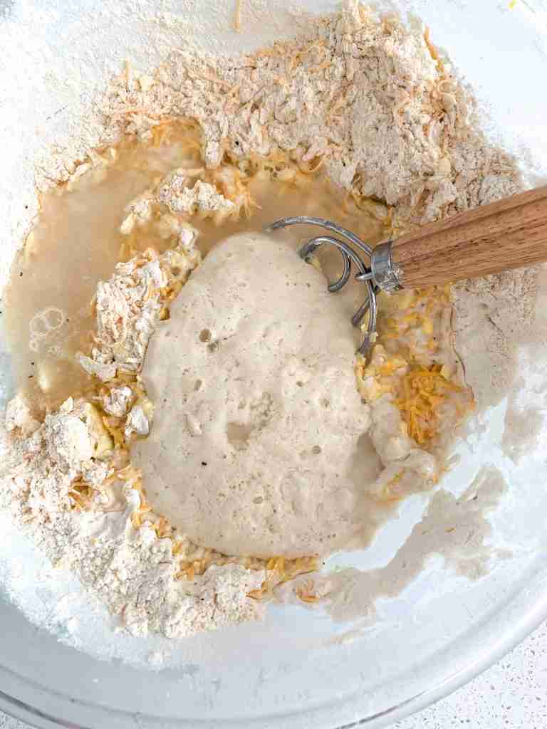 wet ingredients getting whisked into dry biscuit mix