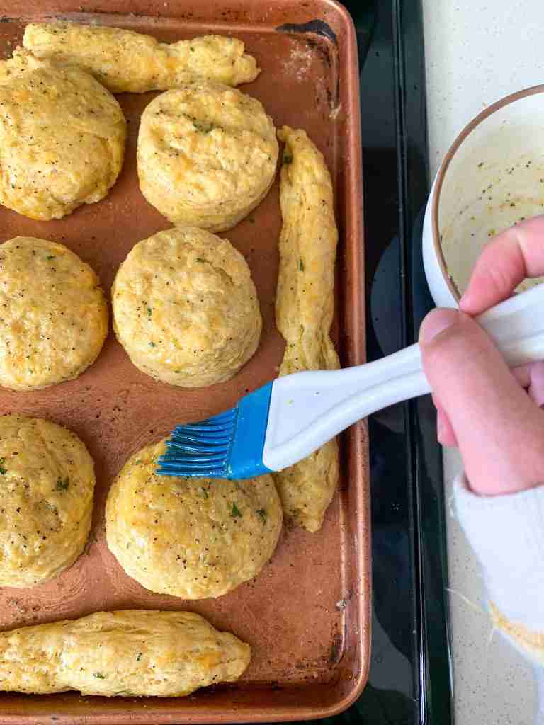 butter getting brushed on biscuits