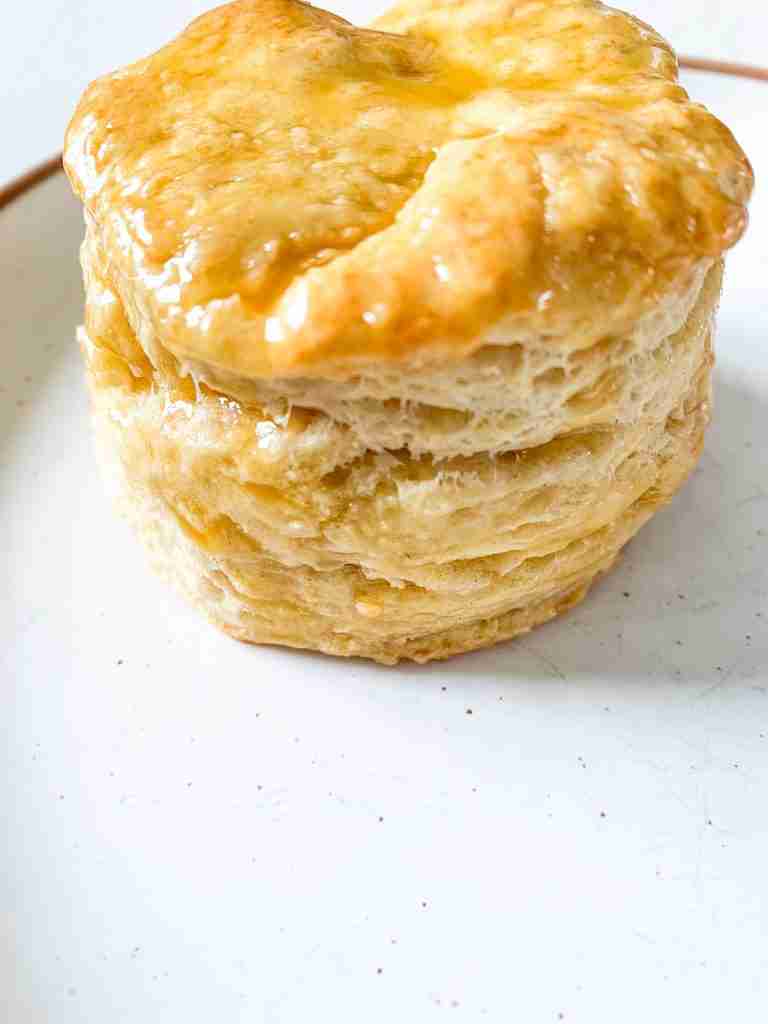 up close biscuits with honey over top on a plate
