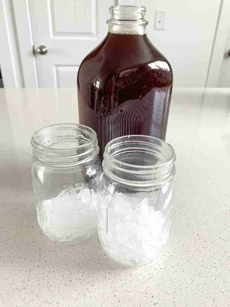 2 glasses of ice with a half gallon of tea behind