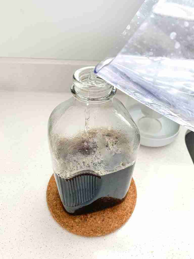 water being poured into bottle of tea