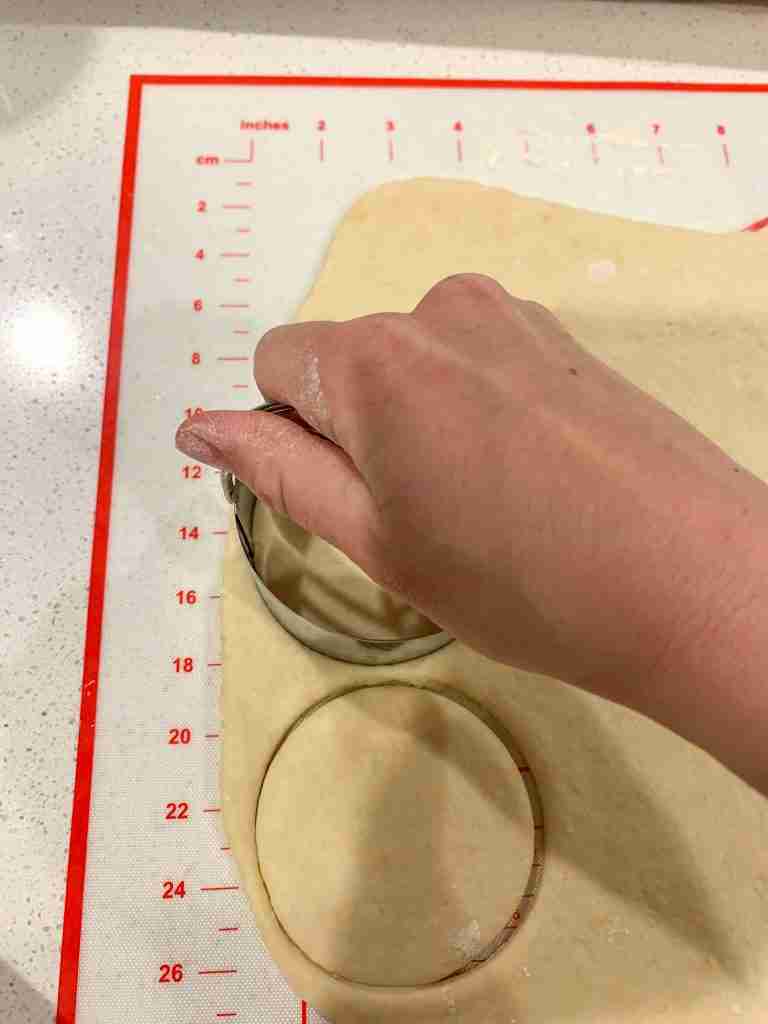 hand cutting out circles of dough