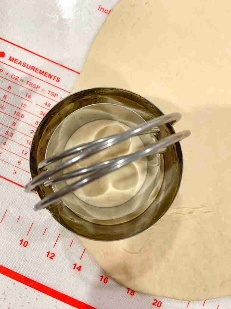 2 biscuit cutters cutting out dough edges