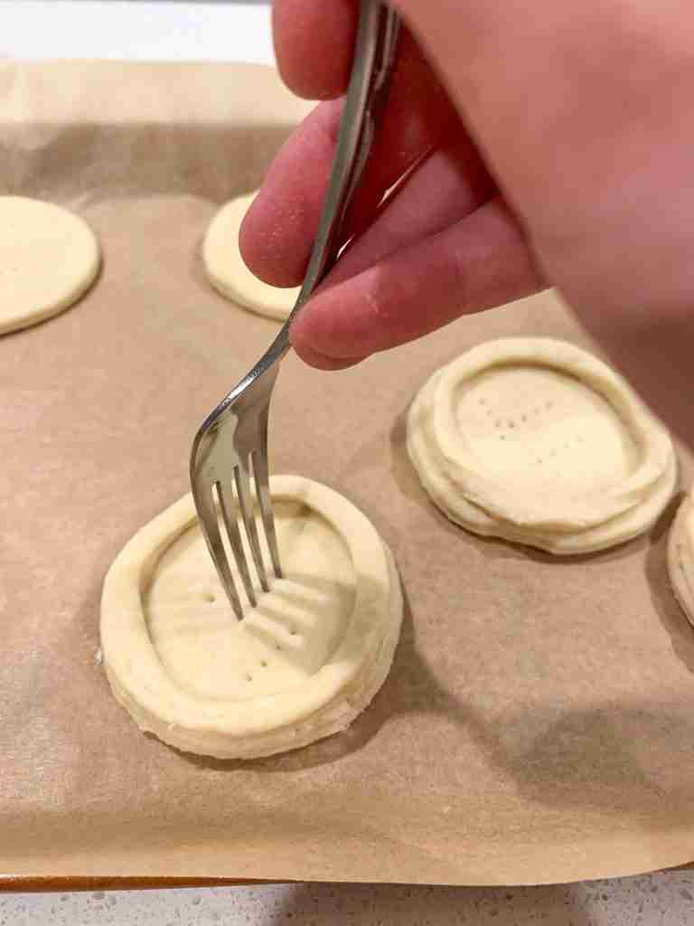 fork poking holes into pastry