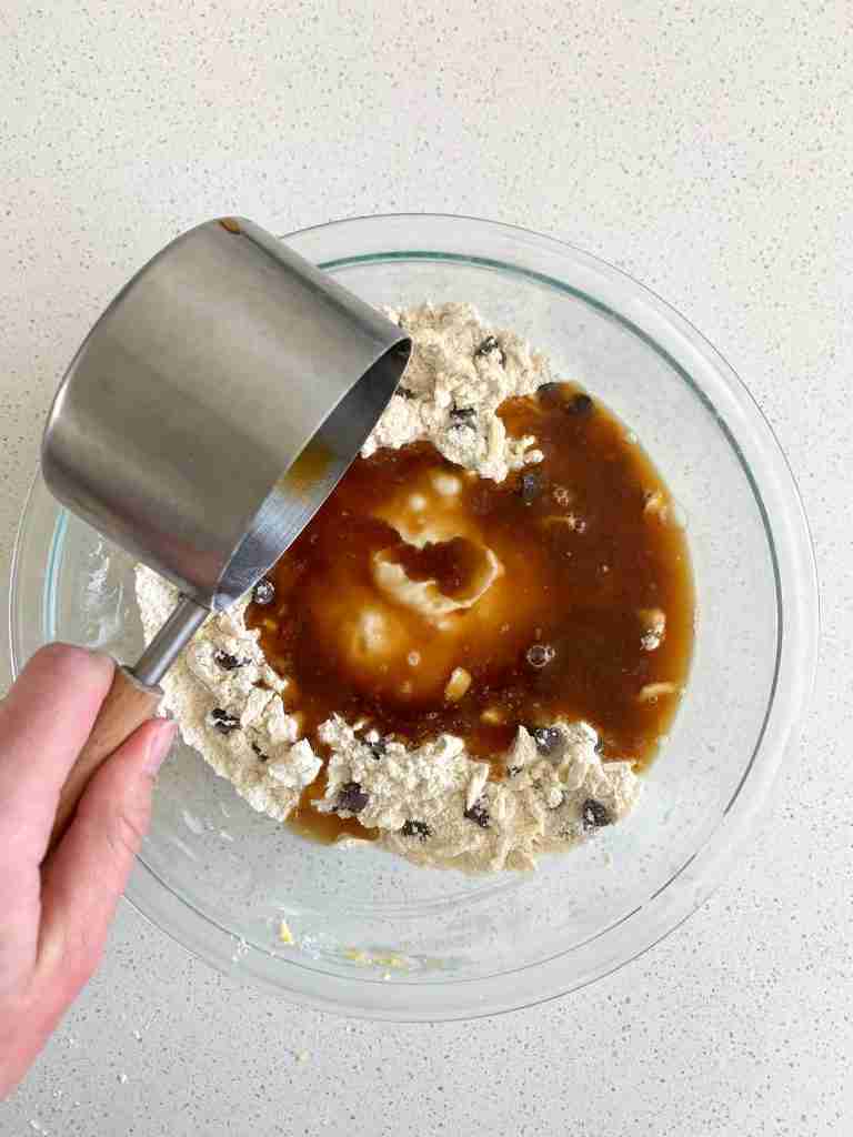 hand pouring coffee into a bowl with flour and ingredients