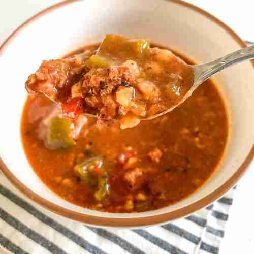 bowl of soup with a spoonful of it up front