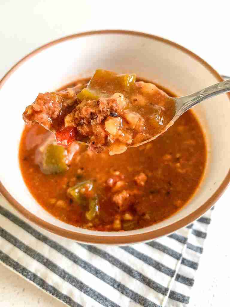 bowl of soup with a spoon holding a spoonful out of the bowl